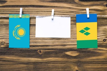 Hanging flags of Kazakhstan and Saint Vincent And The Grenadines attached to rope with clothes pins...