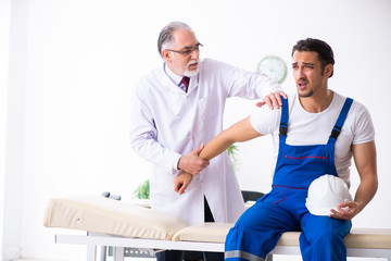 Obraz premium Young male contractor visiting old doctor