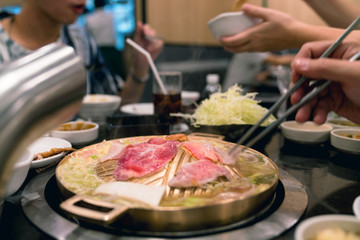 person cooking on brass pan,barbecue grill and vegetable