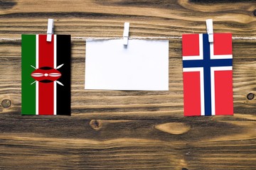 Hanging flags of Kenya and Norway attached to rope with clothes pins with copy space on white note...