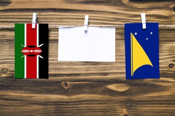 Hanging flags of Kenya and Tokelau attached to rope with clothes pins with copy space on white note...