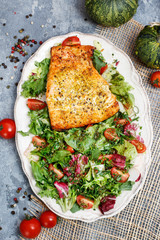 Salmon spiced with herbs and a fresh salad.