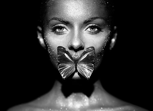 Fashion Model Woman In Bright Sparkles And Lights Posing In Studio. Portrait Of Beautiful Sexy Woman With Butterfly. Art Design Glitter Glowing Make Up. Black And White Photography