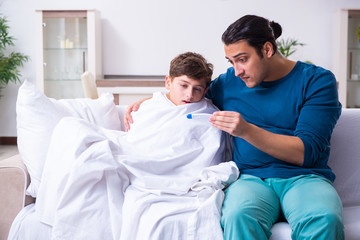 Fototapeta premium Young father caring for sick son