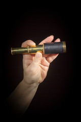 Hand holds spyglass