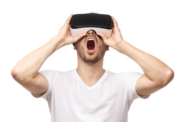 Naklejka premium VR. Close-up studio portrait of screaming young man in virtual reality glasses isolated on white background