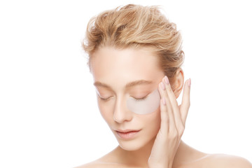 Young woman holding collagen eye patch with one hand, isollated on white background. Perfect clean fresh skin care treatment or cosmetic ads