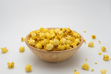 Butter caramel popcorn in wooden bowl bulk on white background, Popular snack with favorite movie