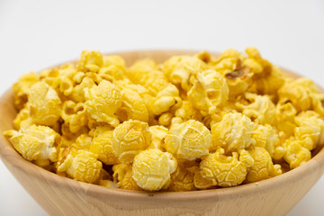 Butter caramel popcorn in wooden bowl bulk on white background, Popular snack with favorite movie