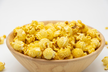 Butter caramel popcorn in wooden bowl bulk on white background, Popular snack with favorite movie