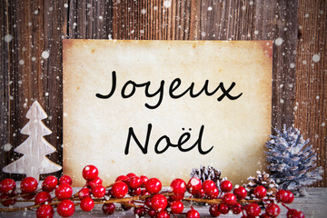 Obraz na płótnie Canvas Paper With French Text Joyeux Noel Merry Christmas. Christmas Decoration And Wooden Background With Snow