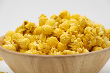 Butter caramel popcorn in wooden bowl bulk on white background, Popular snack with favorite movie