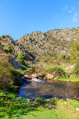 Fototapeta na wymiar River with First fall colors in the mountains of Madrid, Spain