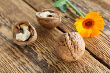Fototapeta na wymiar Walnuts and flower over the wooden natural background