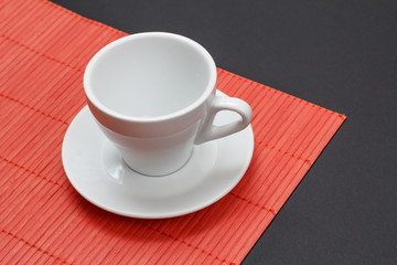 Empty coffee cup on napkin and black background.