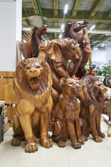 Sale in the store of large and beautiful wooden figures of statues of animal lions, elephants and horses.