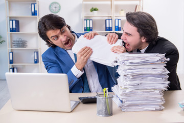 Fototapeta premium Two male colleagues unhappy with excessive work