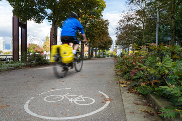 An urban bike route and a cyclist motion blurred travelling past in Olympic Village Vancouver.