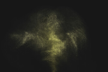 Gold dust glitter shooting spray on black background.