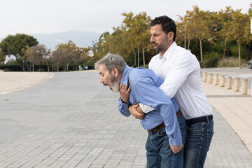 Man doing the Heimlich maneuver to an old man with suffocation due to obstruction of the airway...