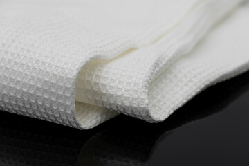 Macro shot texture of folded white towel kitchen fabric isolated on black background
