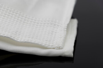 Macro shot texture of folded white towel kitchen fabric isolated on black background