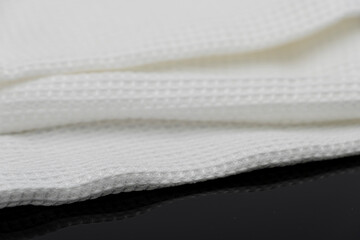 Fototapeta na wymiar Macro shot texture of folded white towel kitchen fabric isolated on black background