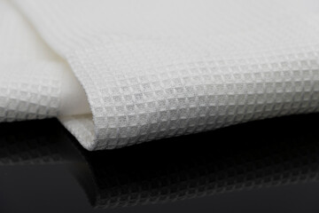 Macro shot texture of folded white towel kitchen fabric isolated on black background