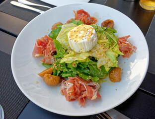 gourmet green salad plate served with proschiutto and ricotta white cheese, top view