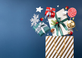 Happy New year magic shopping concept. Christmas gifts, gold bag,Lollipop, decorations and toys are fly or fall in the air on a blue background.