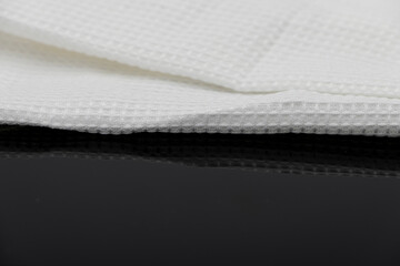 Macro shot texture of folded white towel kitchen fabric isolated on black background