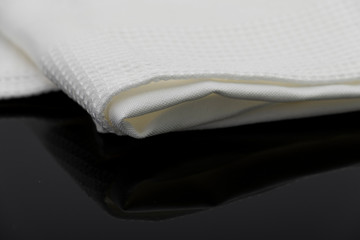 Macro shot texture of folded white towel kitchen fabric isolated on black background