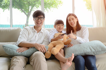 happy family watching TV entertainment together in living room at holiday time weekend, keep watching and teach family member in appropriate content .