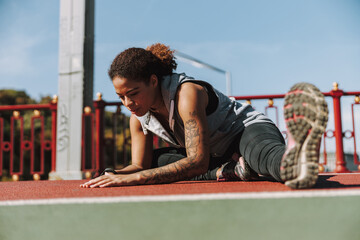 Beautiful Afro American woman doing exercise on the bridge