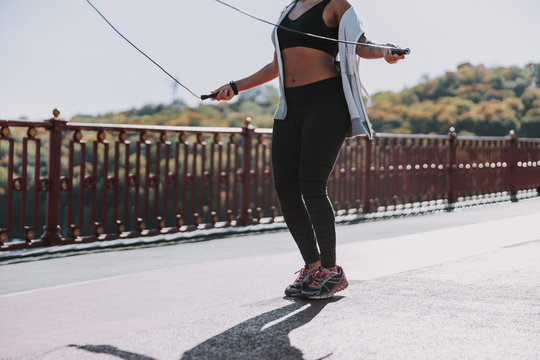 Sporty young woman jumping over skipping rope