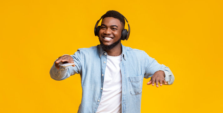 Black guy dancing while listening his favorite music in headphones