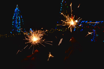 male hand holding a burning sparkler,all festival such as happy diwali, new year eves, Happy...