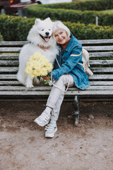 Smiling Caucasian woman hugging nice dog in park