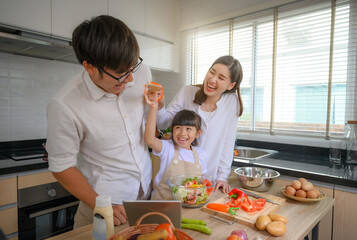 happy family learning cooking together at holidays weekend, teaching daughter cooking online with enjoy and cheerfully action