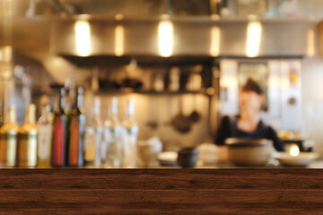 Fototapeta na wymiar Top wood table blur chef cooking in bar restaurant background.For create product display or design key visual layout. Blur bartender serving coffee to customer.