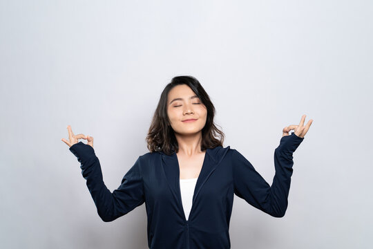 Portrait of a healthy woman meditating holding her hands in yoga gesture isolated on white background