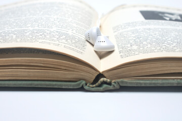 Fototapeta premium open book with headphones. Audiobook concept