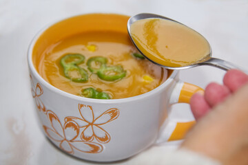 woman eating bowl of soup with spoon