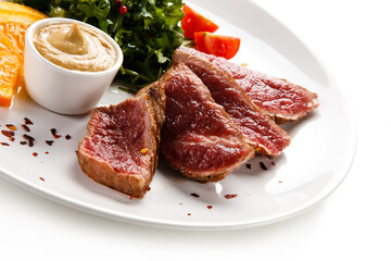 Fillet mignon - grilled beefsteaks with vegetables on white background