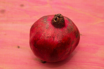 red pomegranate fruit on pink background