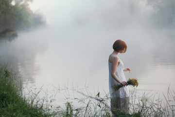 Girl with short hair standing in foggy lake