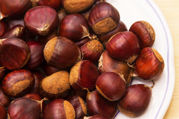 plate full of chestnuts on wood