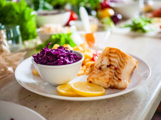 Fish dish - fried fish fillet french fries and vegetables on wooden table