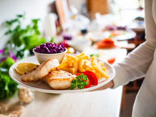 Fish dish - fried fish fillet french fries and vegetables on wooden table