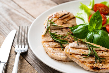 Grilled steaks with vegetable salad on white plate